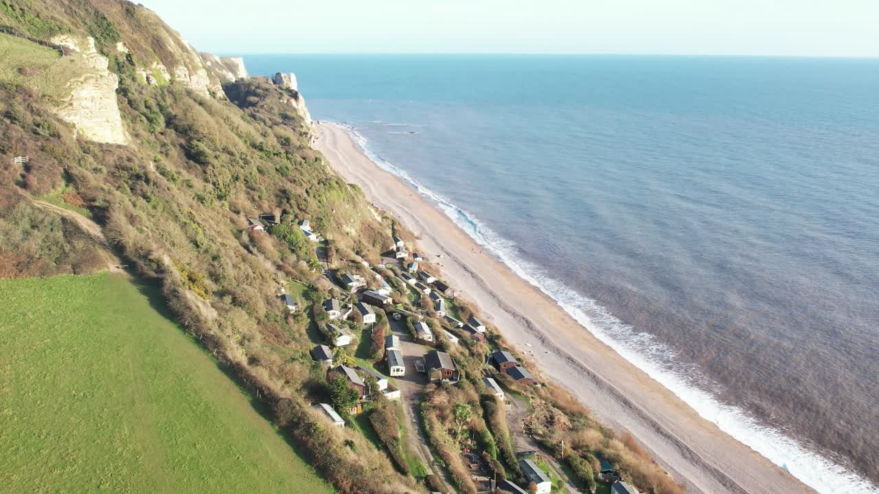 Aerial view of Branscombe village with holiday homes nestled on a picturesque hillside by the sea in Devon, UK