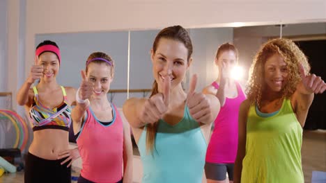 grupo de mujeres en forma sonrientes que muestran los pulgares hacia arriba