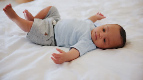 Sweet,-cute-and-boy-baby-on-a-bed-playing