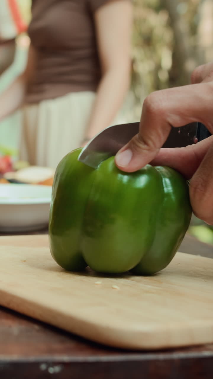 Hands of Man Cutting Bell Pepper on Table