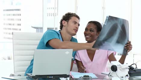 joven médico mostrando rayos x a su colega