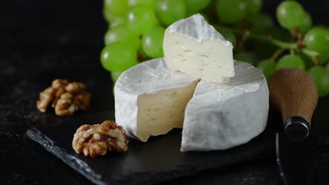 camembert cheese on a stone board rotates slowly.