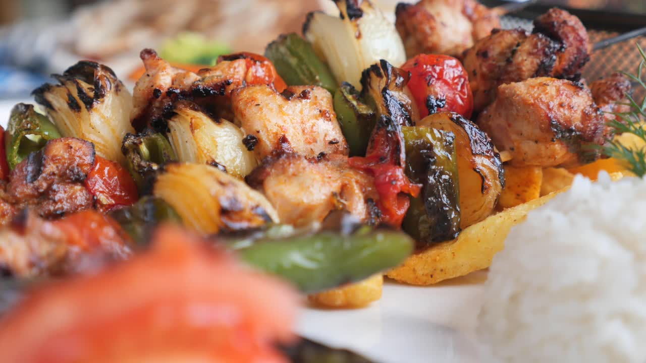 Primo piano di un delizioso shish kebab di pollo con verdure grigliate e riso
