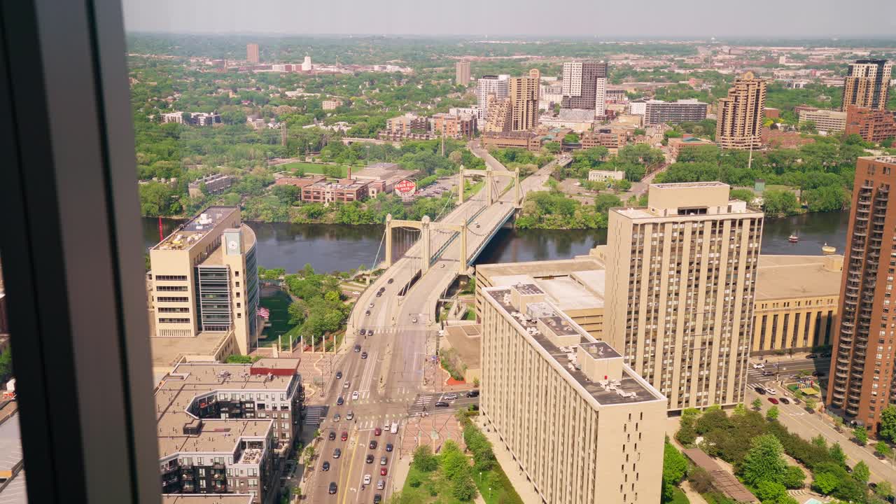 vista desde las ventanas de un edificio de gran altura, destacando un puente que cruza el río mississippi en el centro de minneapolis