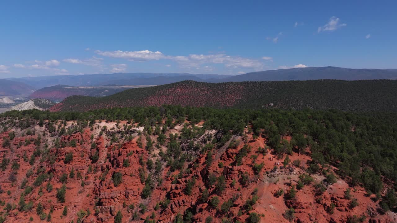 Rugged red slopes of Mushroom Rock glow under bright daylight showcasing sharp textures and ridges, Carbondale Colorado