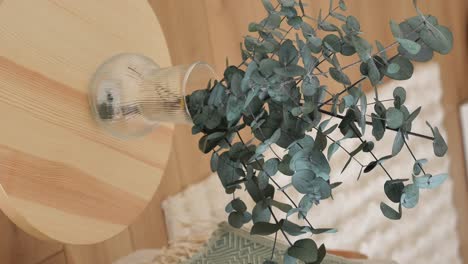 eucalyptus in a glass vase on a round table