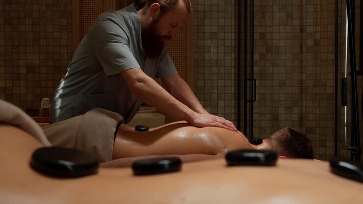 Mand får afslappende hot stone rygmassage på et luksusspa