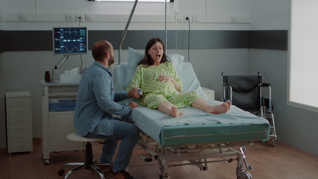 Screaming pregnant woman going into labor in hospital ward