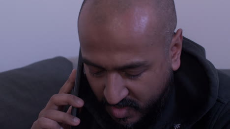 ethnic minority bald male using mobile phone