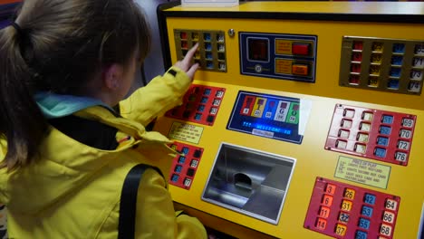 girl in yellow jacket playing prize bingo in an amusement arcade