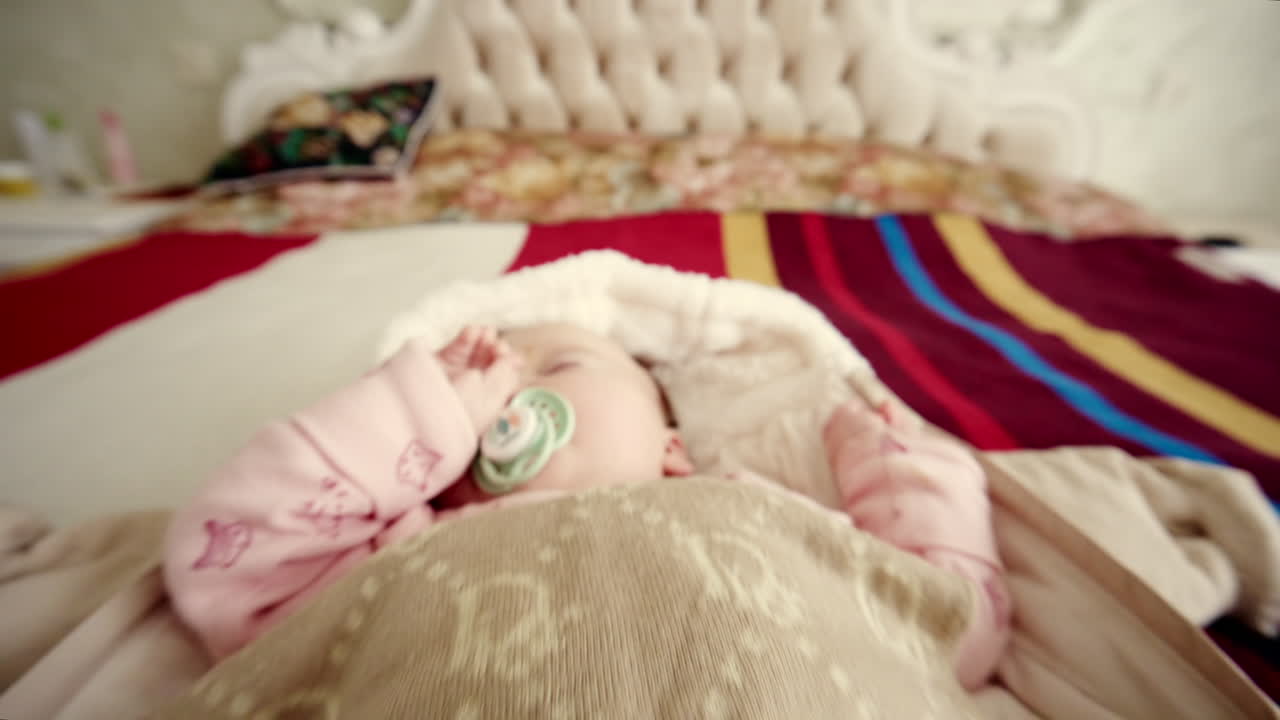 Primo piano di un neonato che dorme serenamente mentre succhia un ciuccio.