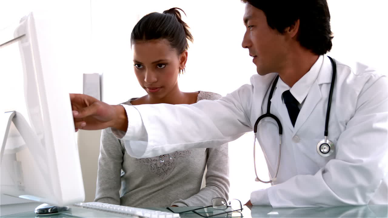 Doctor explaining something on computer to patient