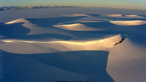 aerial view of snow-covered mountains with golden light