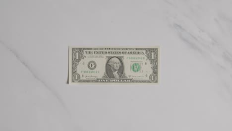 Overhead-Currency-Shot-Of-Hand-Grabbing-US-1-Dollar-Bill-On-Marble-Surface-2