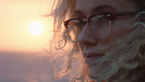 close up portrait of beautiful blonde woman enjoying peaceful seaside at sunset contemplating journey exploring spirituality feeling freedom with wind blowing hair