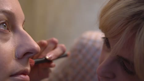 a makeup artist applies eye makeup to a model, demonstrating the skillful techniques used to accentuate natural features