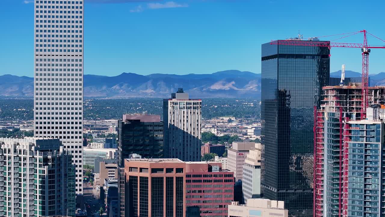 Skyline di Denver con le montagne sullo sfondo, orbita aerea con teleobiettivo, riflesso degli edifici sui vetri