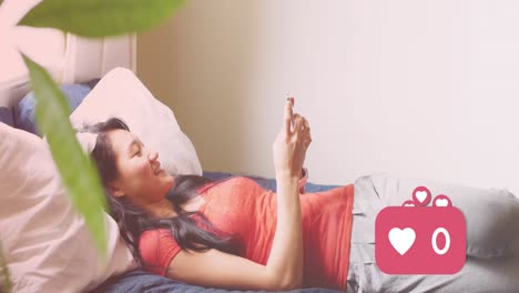 animation of media icons over happy asian woman using smartphone