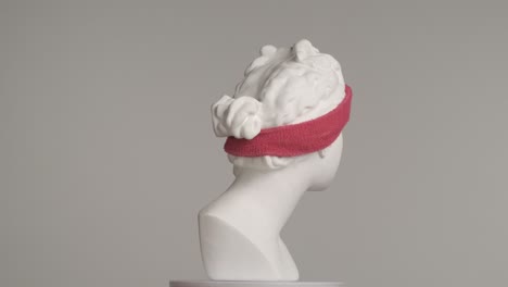 white marble bust with pink headband