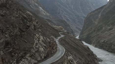 Aerial-drone-forward-moving-shot-of-winding-Skardu-road-surrounded-by-mountain-range-in-Skardu,-Pakistan,-Northern-Area-at-daytime