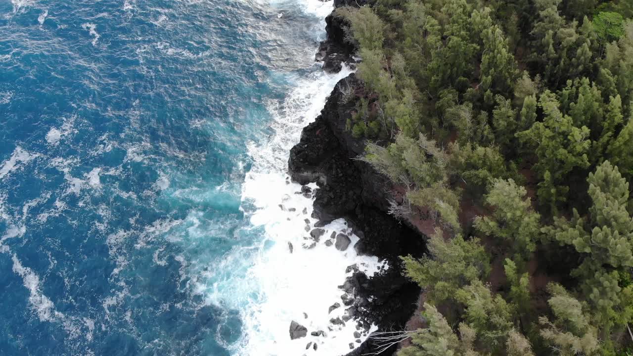 Terbang di atas garis pantai taman negara bagian Mackenzie di Hawaii dengan ombak Pasifik dan tebing hitam