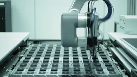 automated robotic arm engaging with electronic chips on a precision assembly line in a scientific laboratory environment