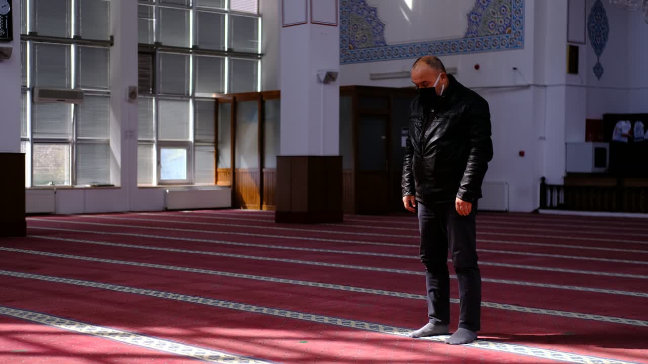 노인은 마스크를 착용하고 모스크에서기도