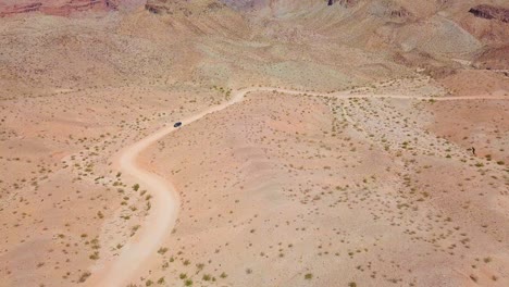 aerial drone view of a car desert dirt road, in sunny kingman wash, arizona, usa