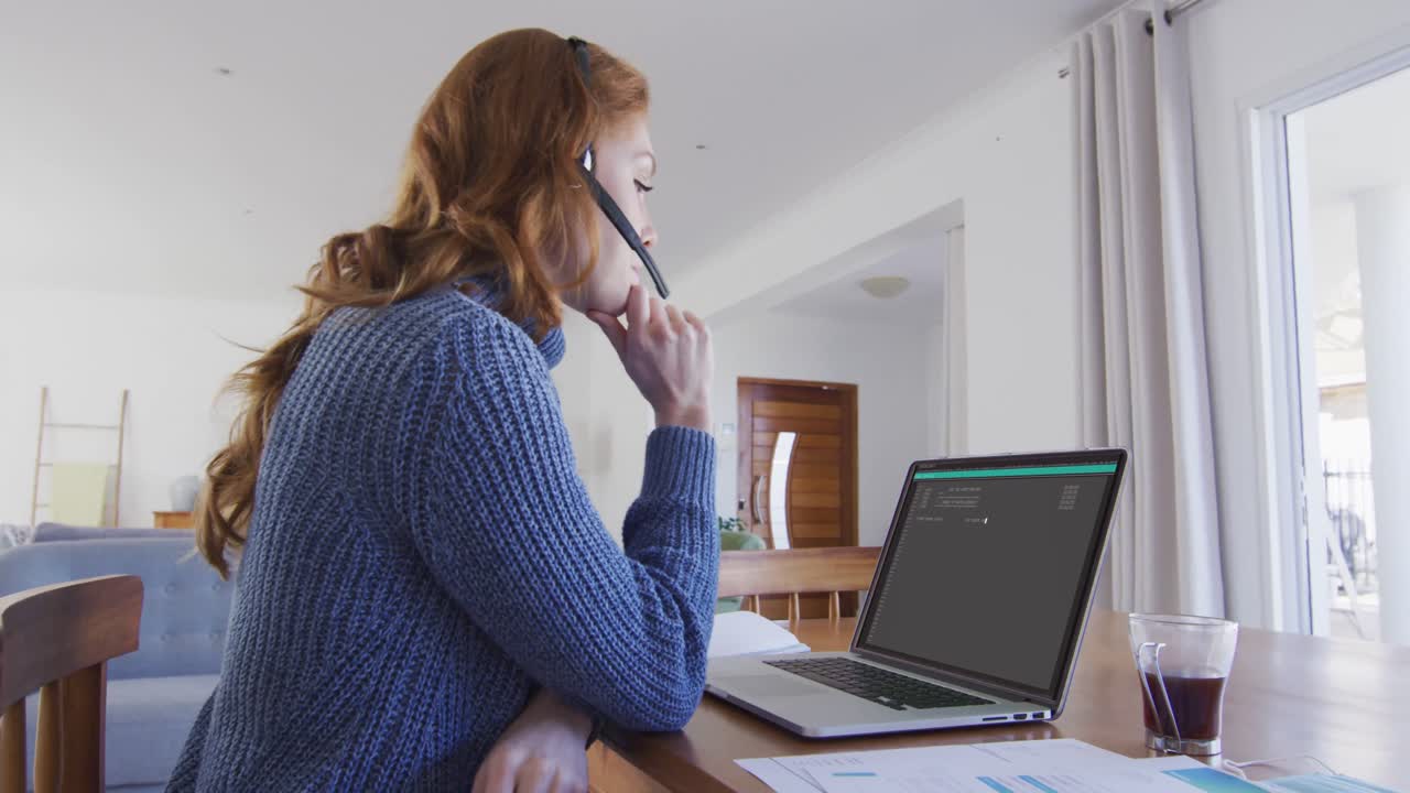 Kaukasische vrouw zittend aan een bureau, data coderend op een laptop