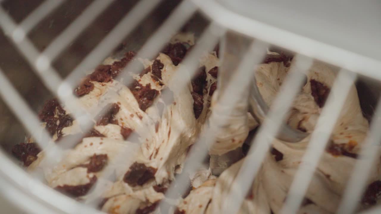 смешивание дрожжевого теста с сушеными помидорами в промышленном смесителе