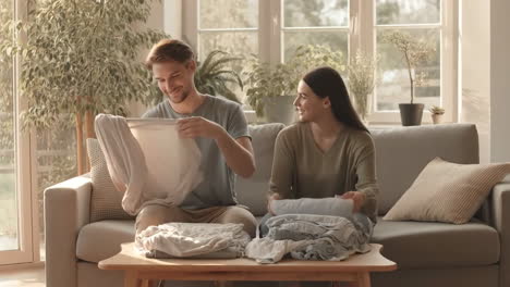 happy couple folding laundry together at home