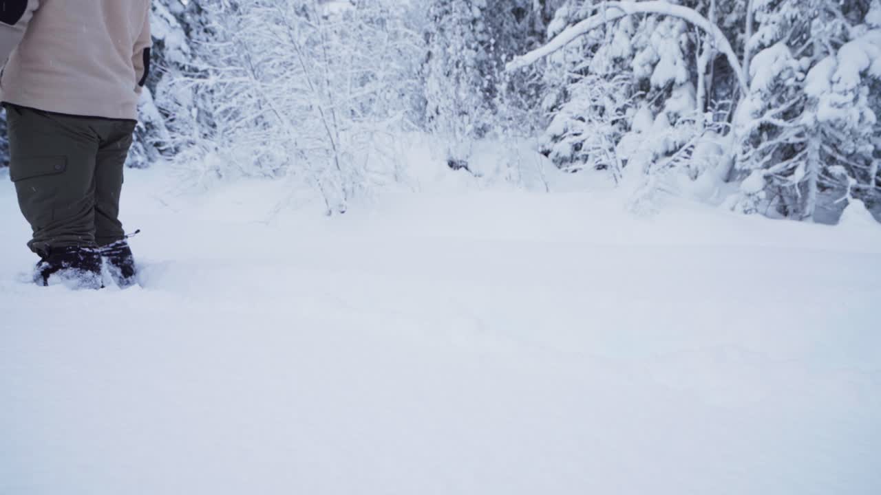 piernas de un hombre caminando en la nieve profunda con nieve cayendo durante el invierno en noruega