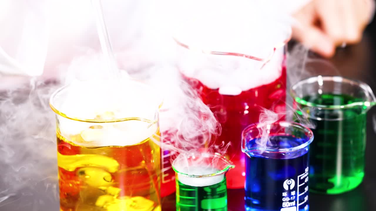 다채로운 액체와 증폭하는 연기가 있는 컵