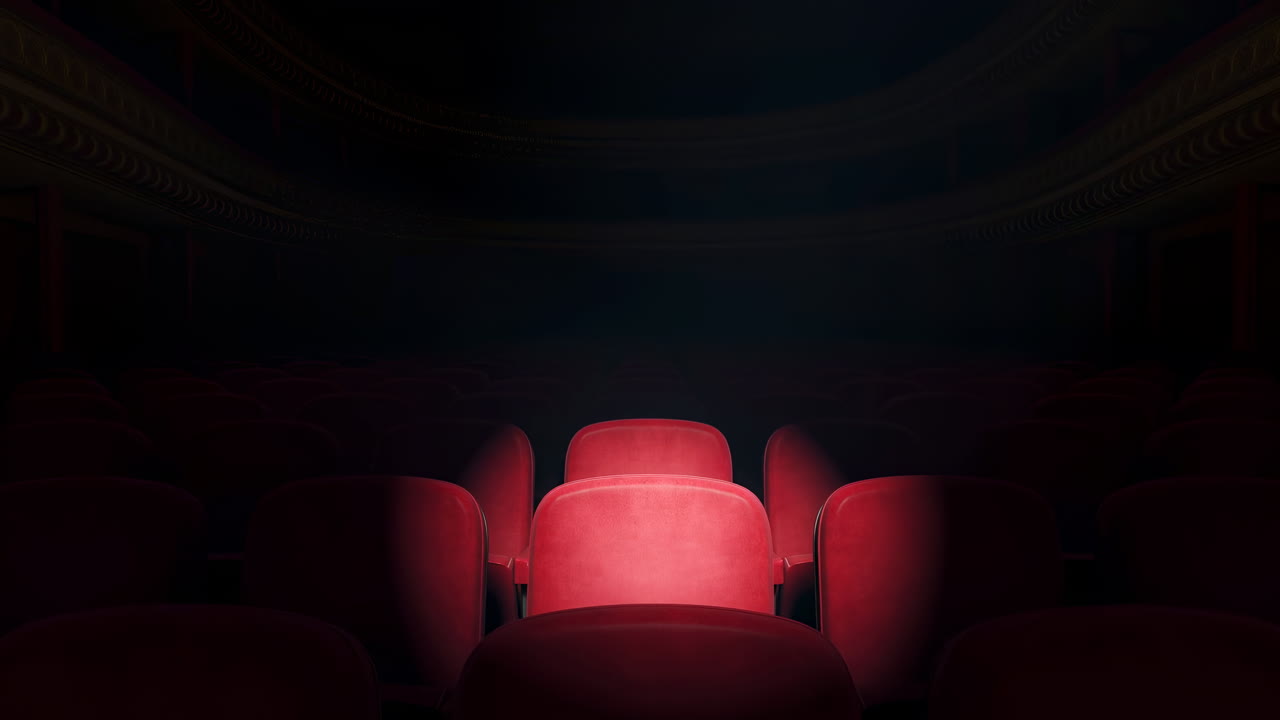 Poltrona da teatro rossa illuminata da un riflettore, rivestimento in velluto che risplende contro l'oscurità dell'auditorium, un singolo raggio