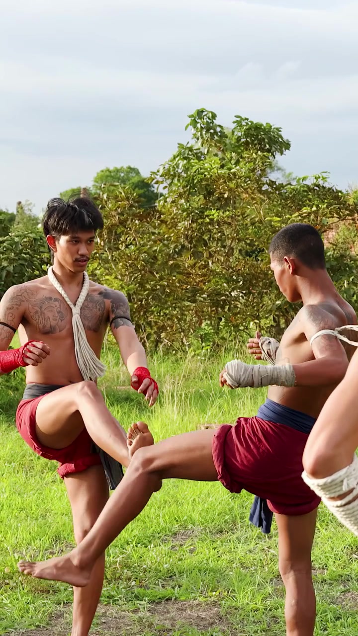 Luchadores de Muay Thai practicando patadas en una sesión de entrenamiento al aire libre