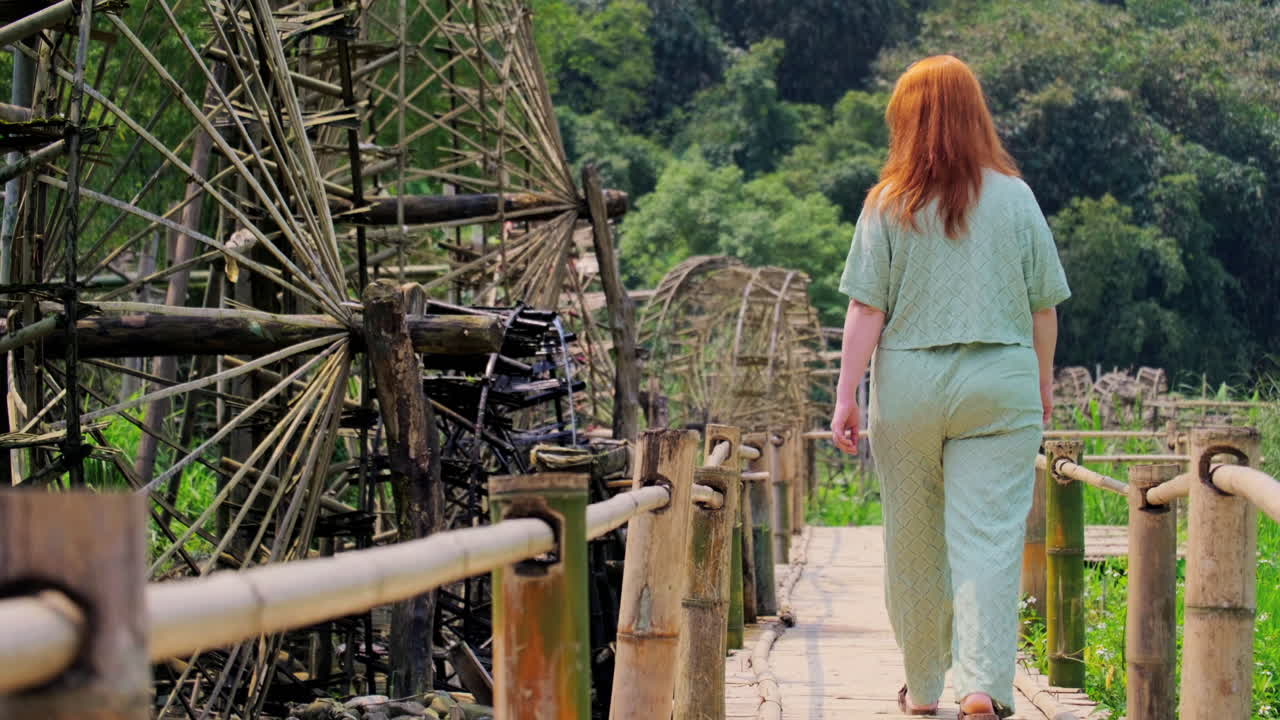 Female Tourist Walking On The Wooden Footbridge In Pu Luong Ancient Waterwheels In Vietnam. Static Shot