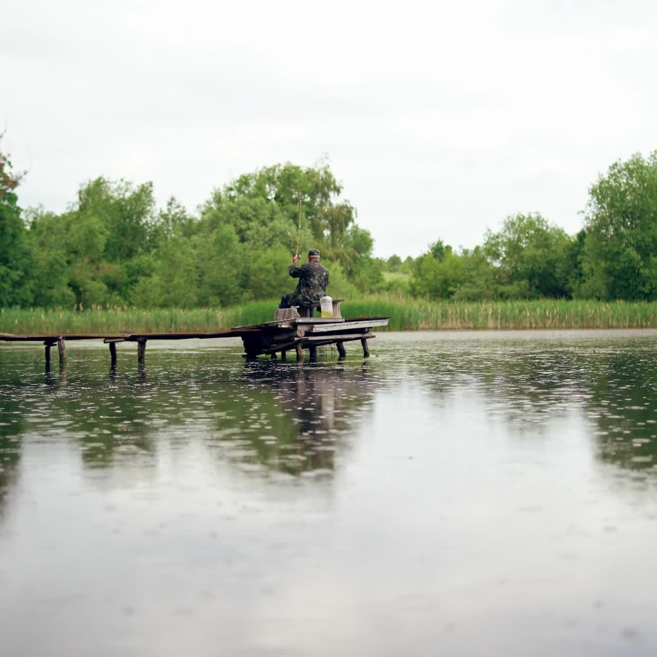 Fisherman catching fish on lake