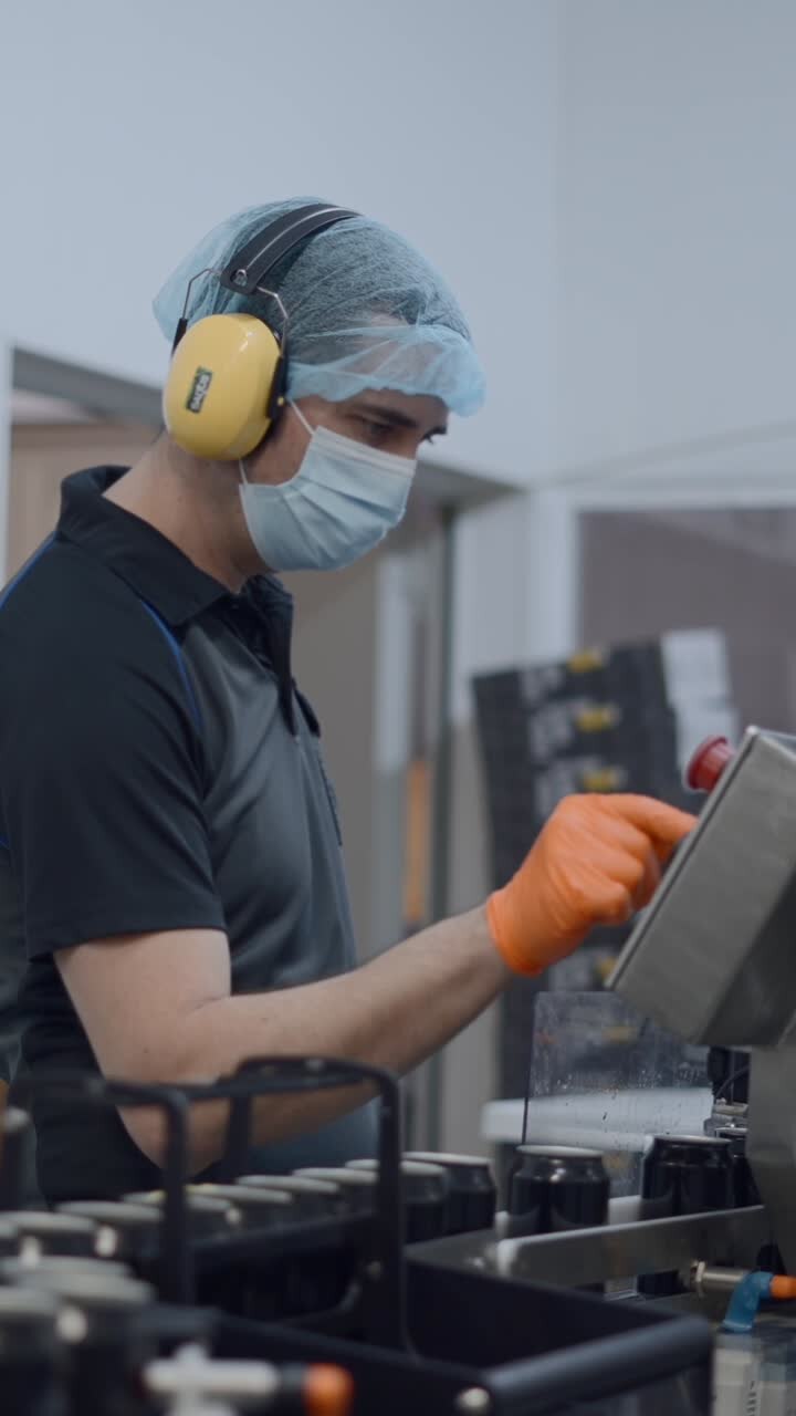 Worker in PPE operates machinery in a production facility