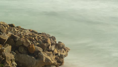 rocky shore and ocean waves, time lapse close up view