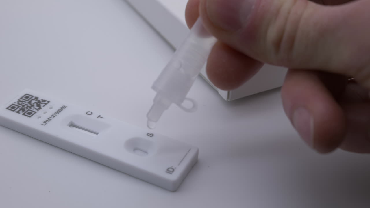 Close up man using at home Covid-19 rapid flow antigen testing kit