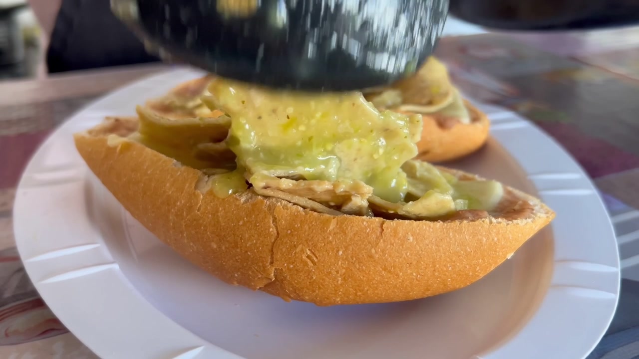 Primo piano: porzione di torta di chilaquiles verdi con formaggio fuso.