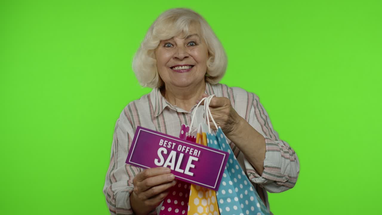 노인 할머니는 쇼핑 가방에서 최고의 제안 판매 문구를 보여주고, 좋은 할인을 기합니다.