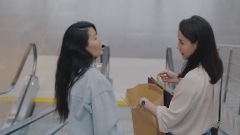 two women shopping on an escalator