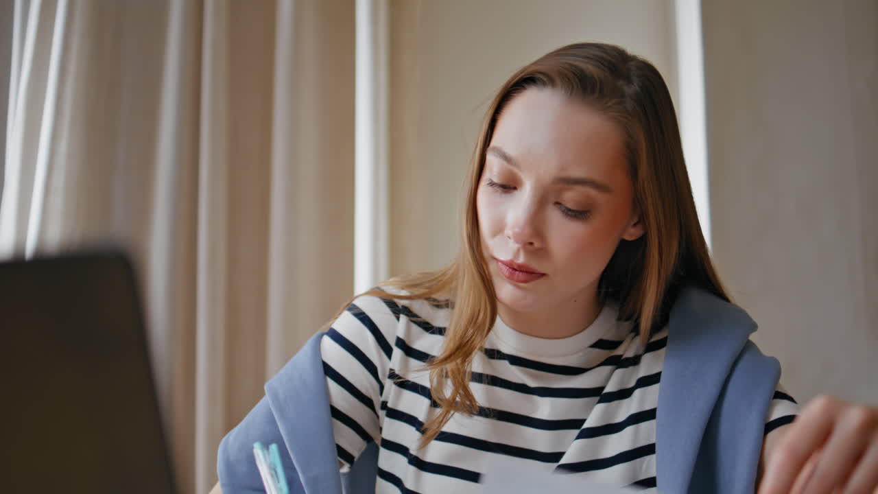 Primo piano di una studentessa modello che fa i compiti a casa. Donna che scrive una relazione