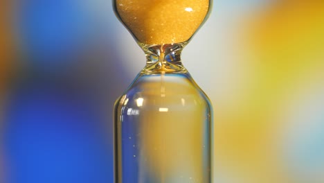 hourglass. super close-up view of sand flowing through an hourglass