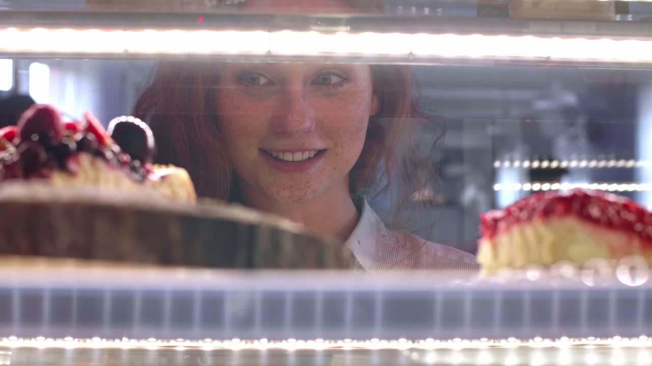 Donna che sceglie una torta al bar