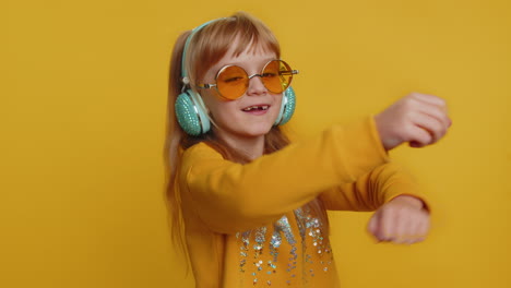happy preteen child girl kid listening music via headphones and dancing disco fooling around
