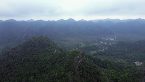pan right movement along coastal area with tropical forest and rocky peaks
