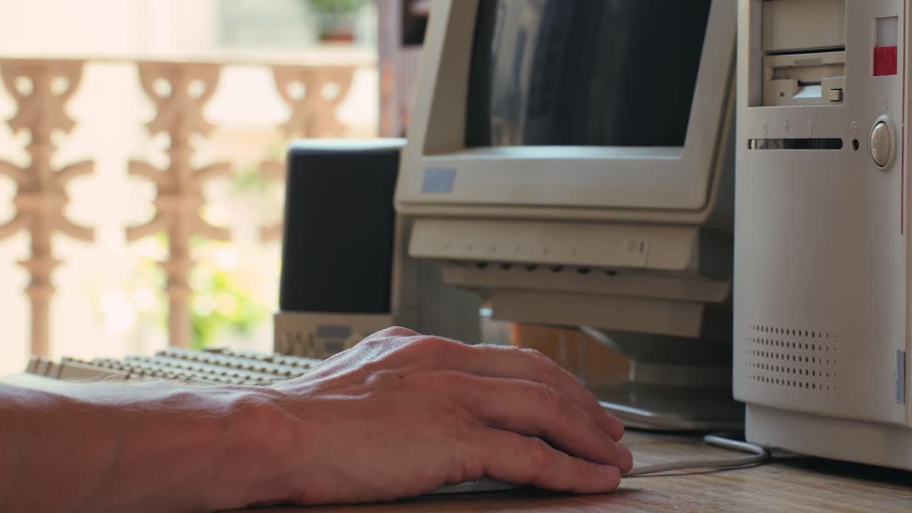 Man working and gaming on retro computer PC, IT engineer with vintage computer at home, using old fashion technology, close up of retro setup.