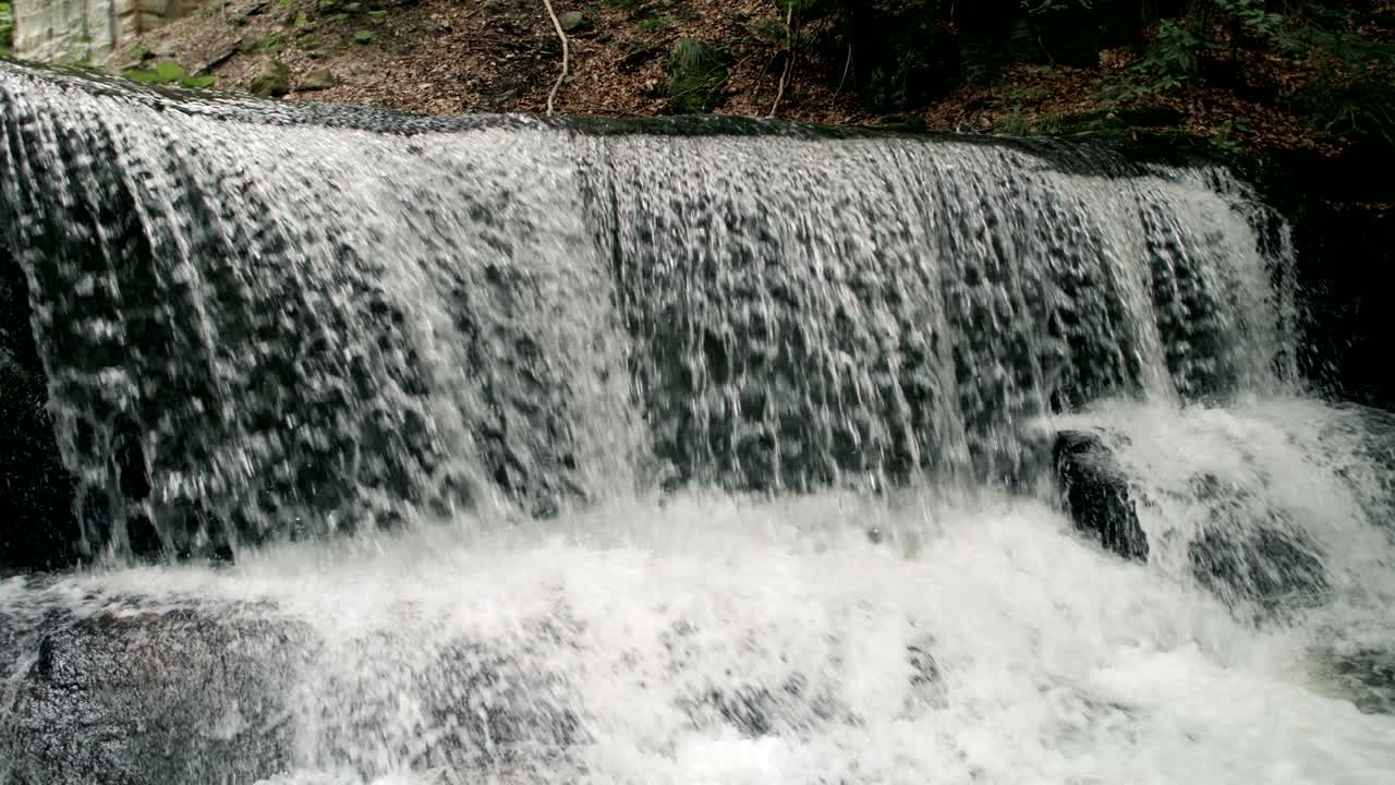 Slowmotion af et episk vandfald og en romersk bro